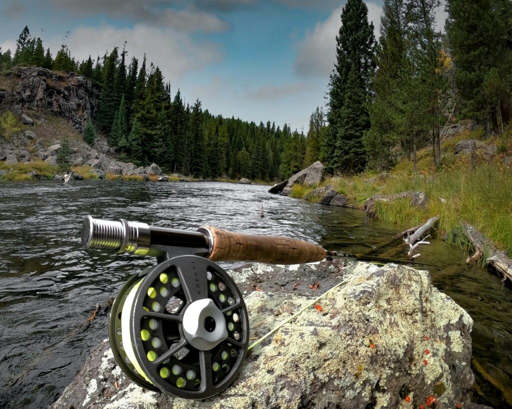 Fly rod sitting on a rock overlooking the river