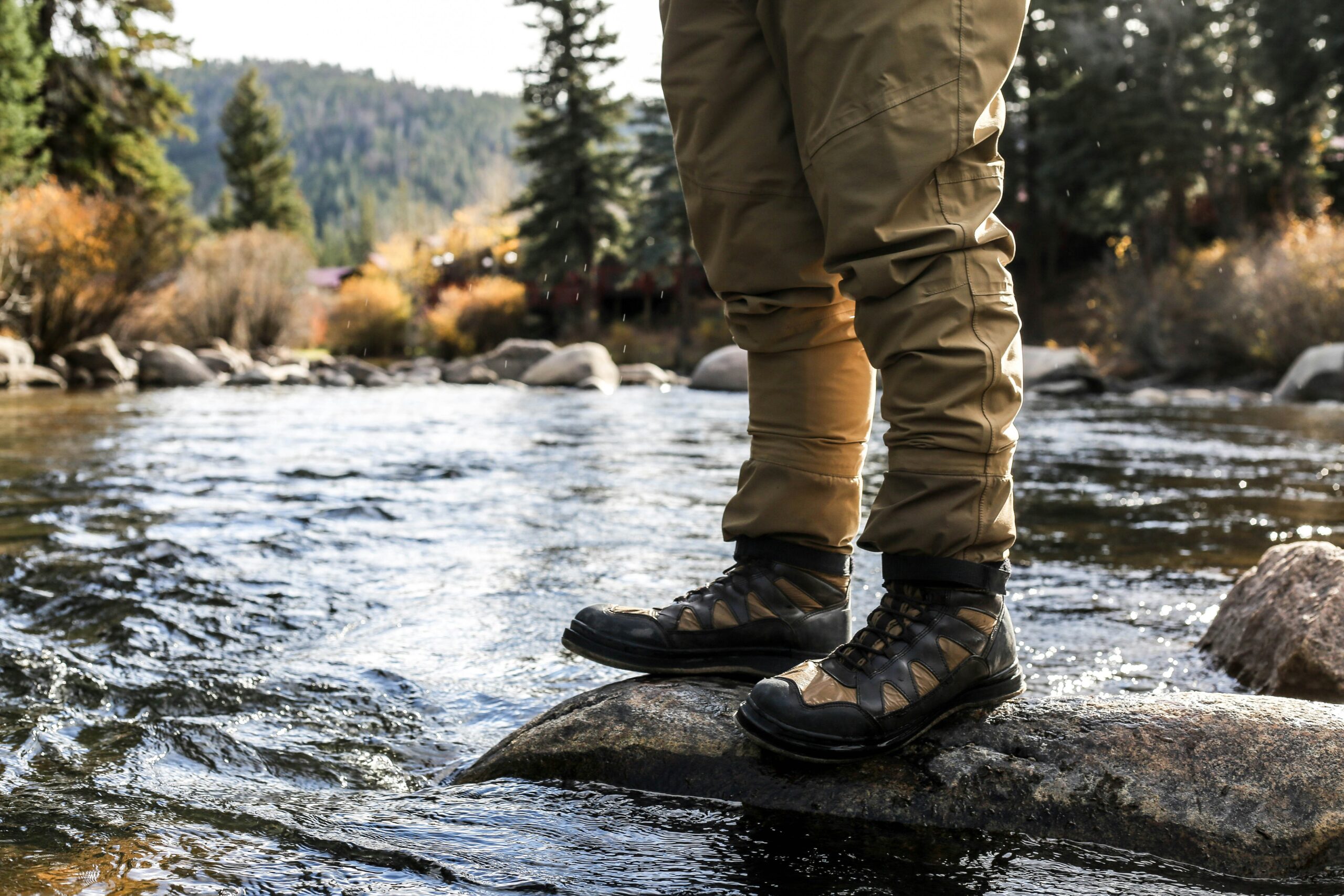 river scene with a persons boots and legs in the picture 